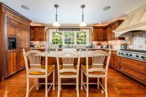 a kitchen with stainless steel appliances granite countertop a sink and a wooden floors
