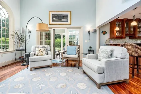 a living room with furniture a fireplace and a large window