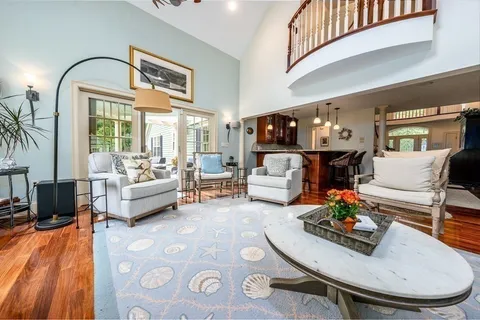 a living room with furniture a chandelier and a fireplace