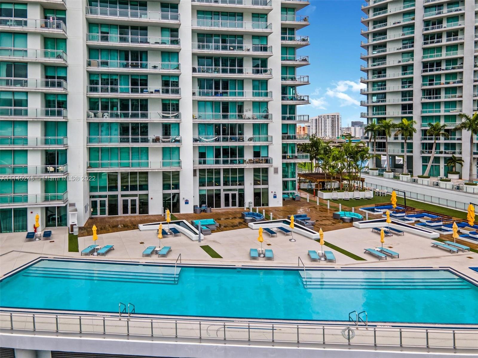 92 Southwest 3rd Street, Unit 901 Miami, FL 33130 - Photo 23 of 35 a view of swimming pool with a lounge chairs in front of house