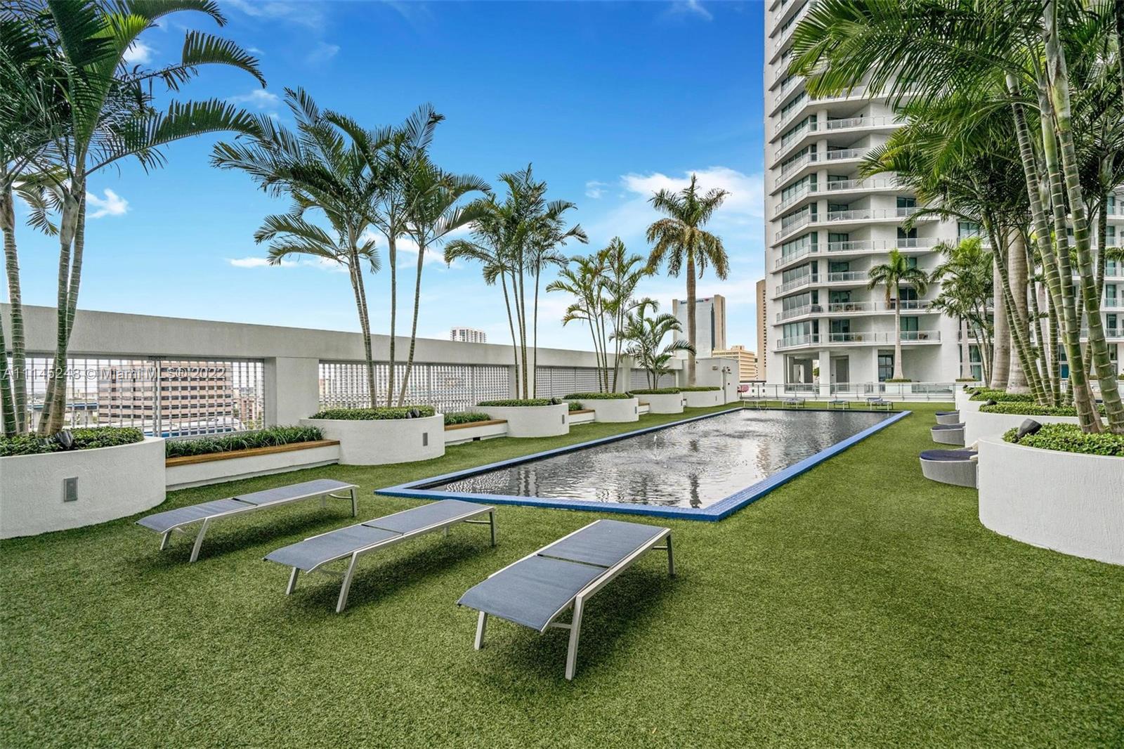 92 Southwest 3rd Street, Unit 901 Miami, FL 33130 - Photo 25 of 35 a swimming pool with outdoor seating and yard