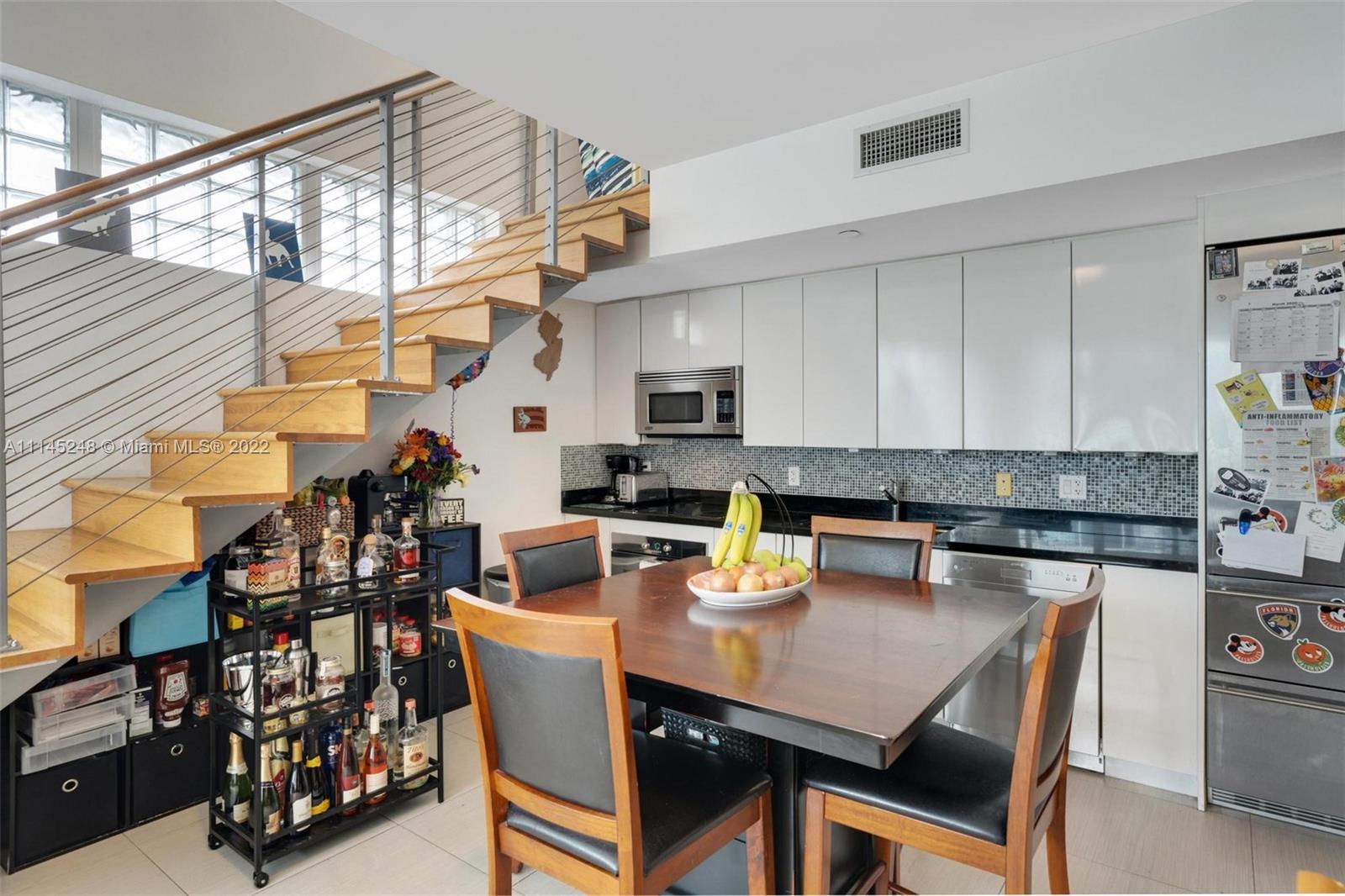 92 Southwest 3rd Street, Unit 901 Miami, FL 33130 - Photo 10 of 35 a kitchen with a sink a stove and chairs