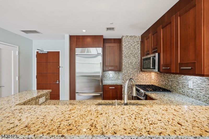 8100 River Road, Unit 210 North Bergen, NJ 07047 - Photo 6 of 25 a kitchen with stainless steel appliances kitchen island granite countertop a refrigerator and a sink