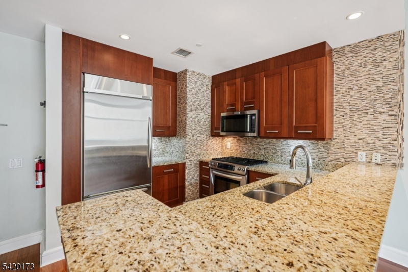 8100 River Road, Unit 210 North Bergen, NJ 07047 - Photo 8 of 25 a kitchen with stainless steel appliances granite countertop a refrigerator sink and stove