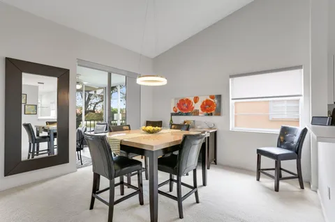 a view of a dining hall with furniture and a kitchen