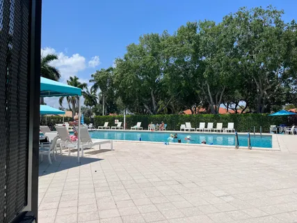 a living room with furniture a rug and kitchen view