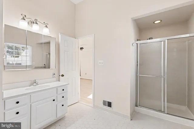 a spacious bathroom with double sink and a mirror