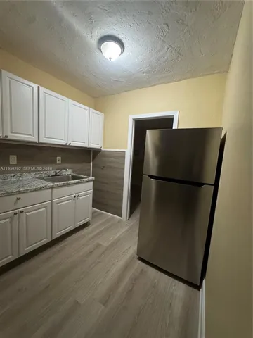 a kitchen with stainless steel appliances granite countertop a refrigerator sink and cabinets