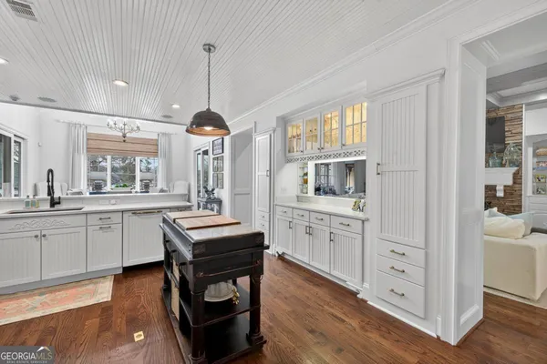 a dining room with wooden floor a chandelier