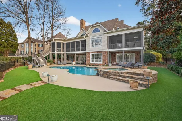 a view of a swimming pool with a yard and sitting area