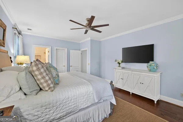 a bed room with a bed a flat screen tv and a dresser