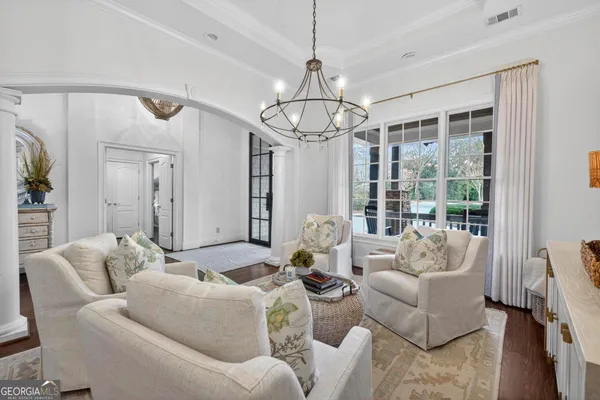 a living room with furniture and a dining table with wooden floor