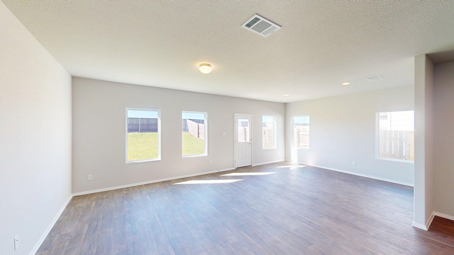5509 Sacra Cove Austin, TX 78747 - Photo 14 of 38 an empty room with windows and wooden floor