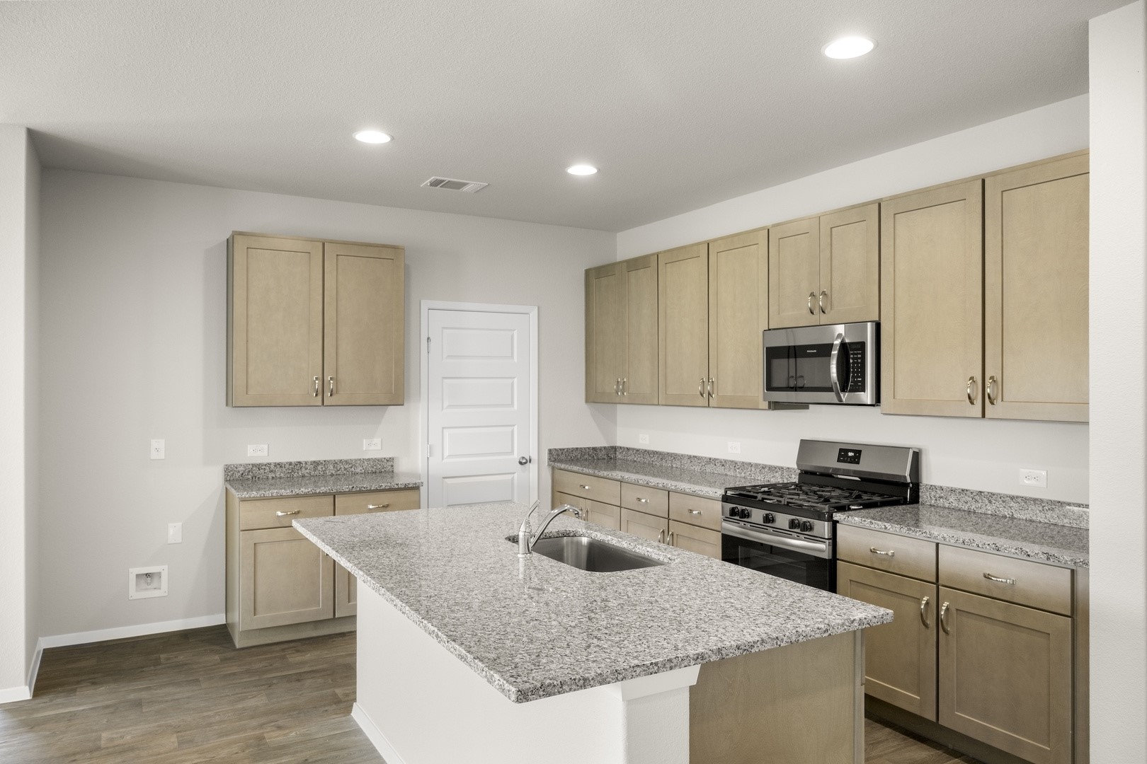 5509 Sacra Cove Austin, TX 78747 - Photo 25 of 38 a kitchen with granite countertop a sink a stove and cabinets