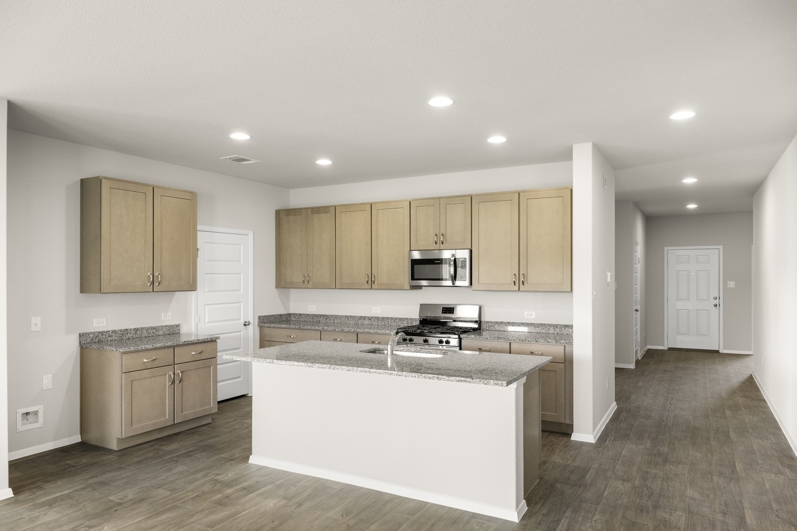 5509 Sacra Cove Austin, TX 78747 - Photo 26 of 38 a kitchen with kitchen island sink stove and white cabinets