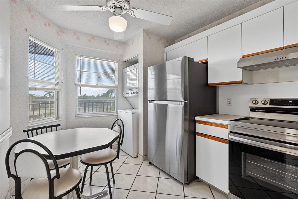 650 Southwest 124th Terrace, Unit 404P Pembroke Pines, FL 33027 - Photo 8 of 26 a kitchen with stainless steel appliances granite countertop a refrigerator a stove a sink dishwasher and white cabinets with wooden floor