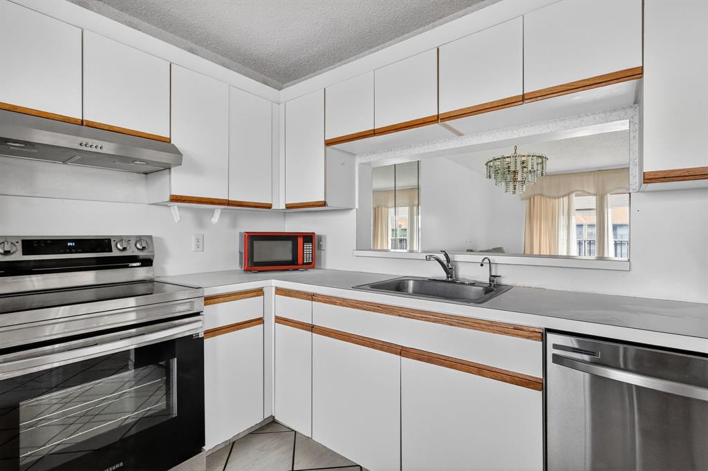 650 Southwest 124th Terrace, Unit 404P Pembroke Pines, FL 33027 - Photo 10 of 26 a kitchen with granite countertop cabinets stainless steel appliances and a sink