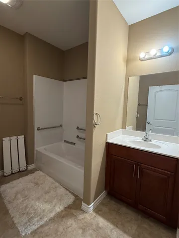 a bathroom with a tub sink and mirror