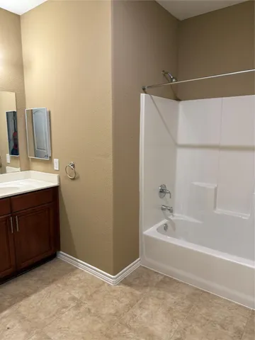 a spacious bathroom with a bathtub sink and mirror