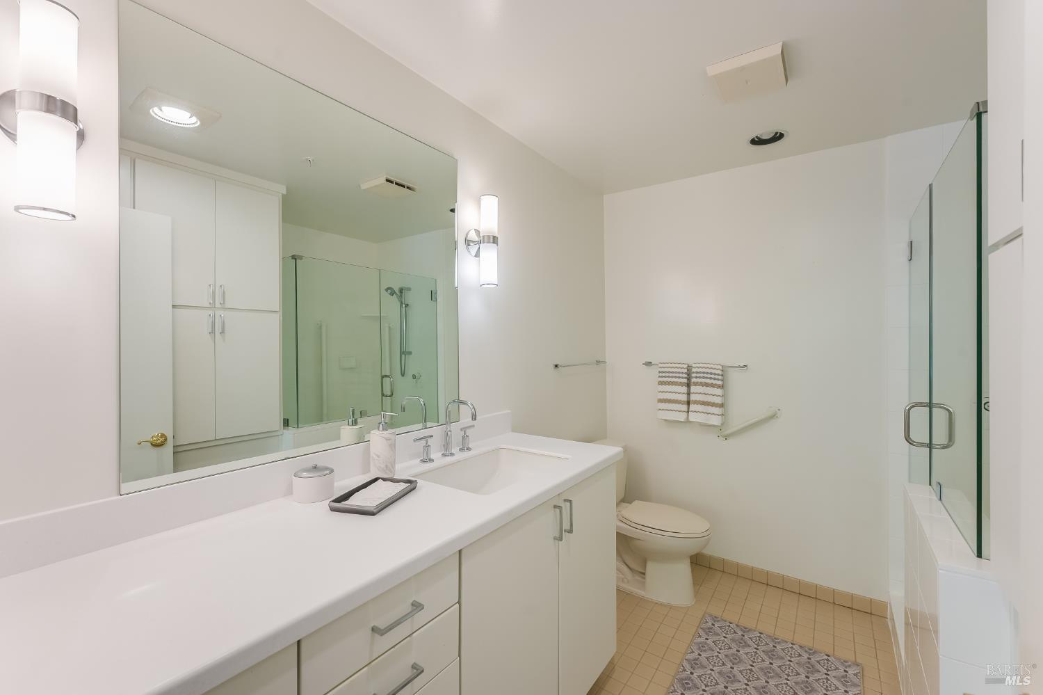 400 Deer Valley Road, Unit 2G San Rafael, CA 94903 - Photo 14 of 26 A fantastic updated bathroom includes seamless shower glass, Updated countertops and storage shelving over tub.