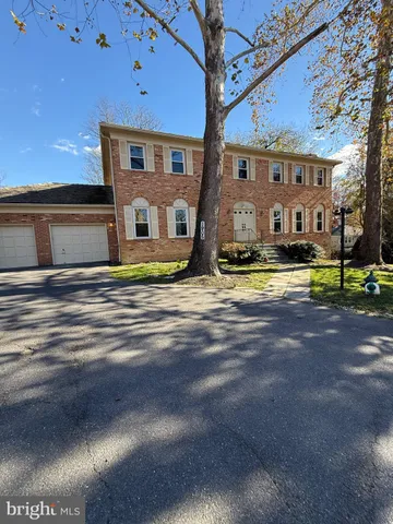 a front view of a building with lake view and trees