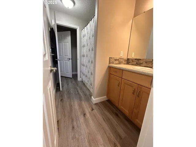 a kitchen with granite countertop a sink cabinets and wooden floor