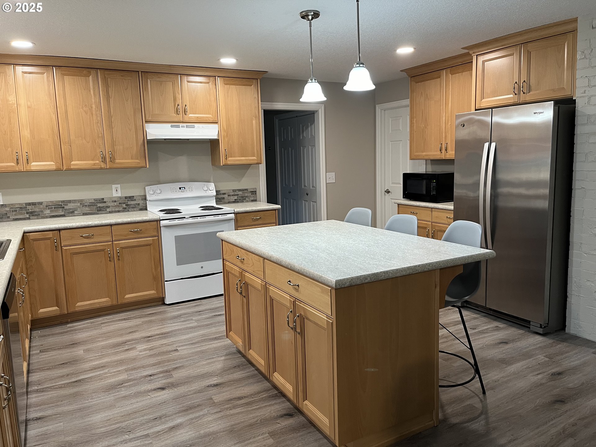 1305 Northeast Newall Road Newberg, OR 97132 - Photo 20 of 21 a kitchen with stainless steel appliances a stove a refrigerator a sink a center island and wooden floor