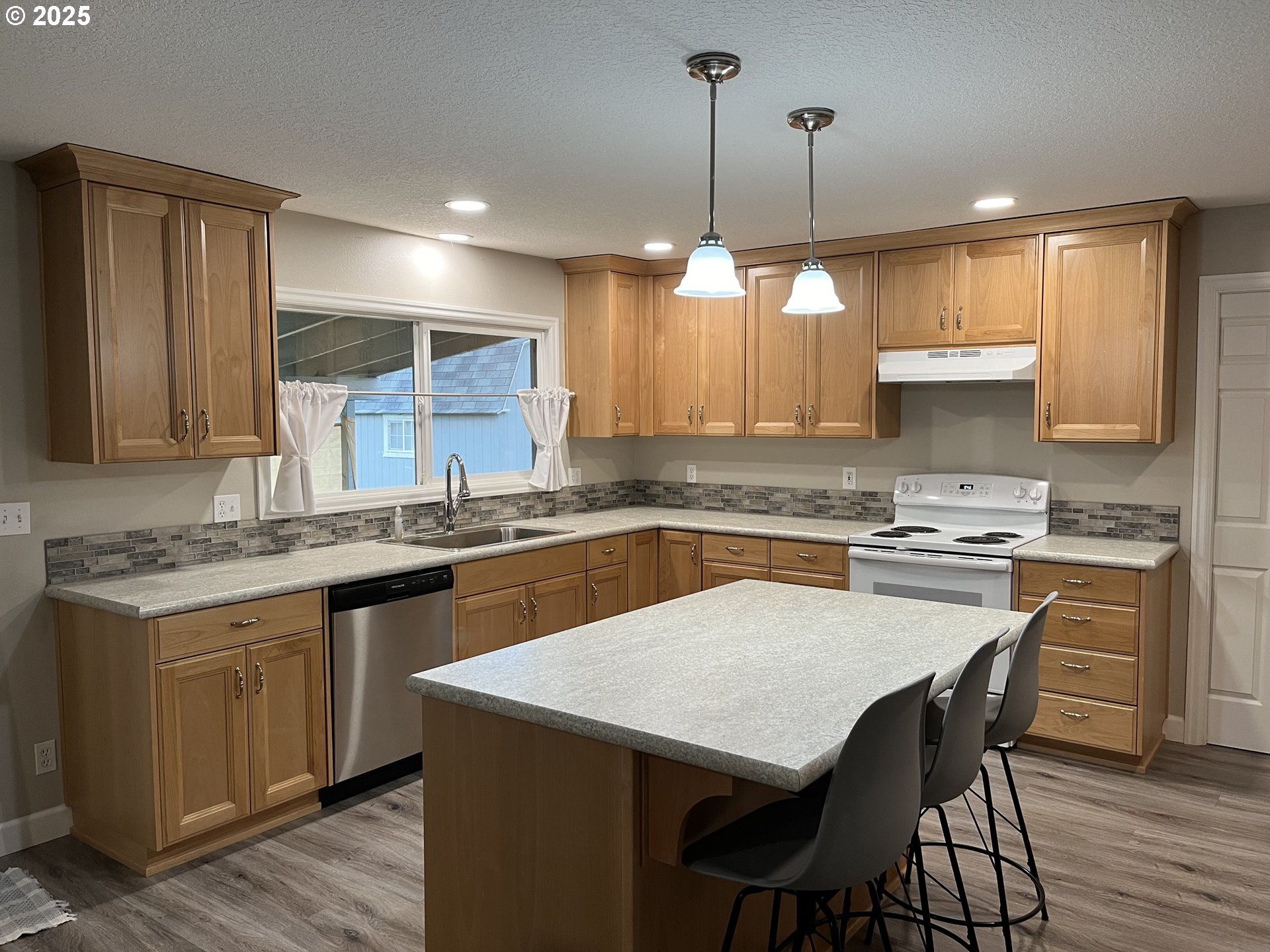 1305 Northeast Newall Road Newberg, OR 97132 - Photo 21 of 21 a kitchen with a stove a sink a dining table and chairs