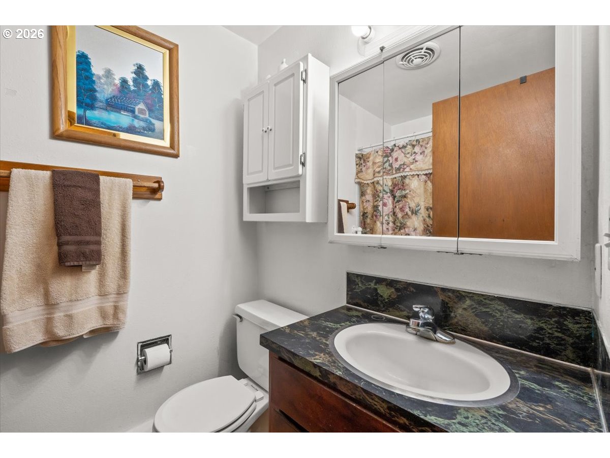 904 South Magnolia Street Cornelius, OR 97113 - Photo 6 of 28 a bathroom with a granite countertop sink a mirror and a toilet