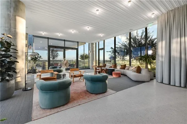 a living room with furniture and a floor to ceiling window
