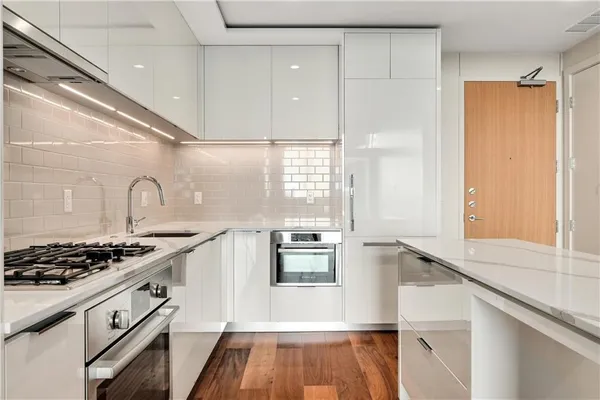 a kitchen with granite countertop a stove and a refrigerator