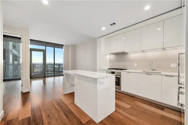 a kitchen with white cabinets and wooden floor