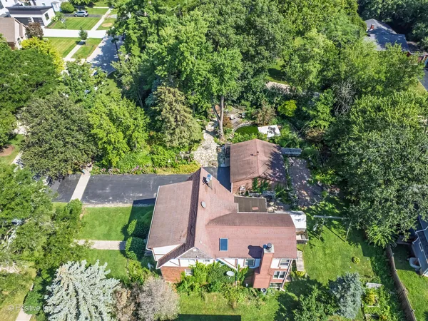an aerial view of a house with garden space and a street view