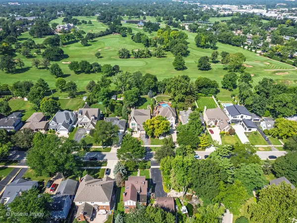 an aerial view of residential houses with outdoor space and trees