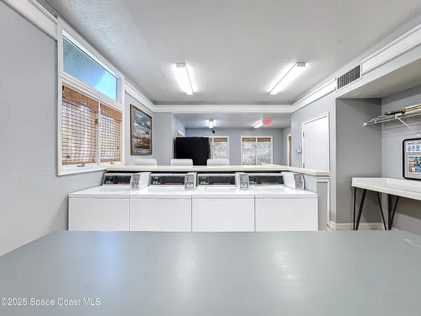 a large white kitchen with stainless steel appliances granite countertop a stove and a refrigerator