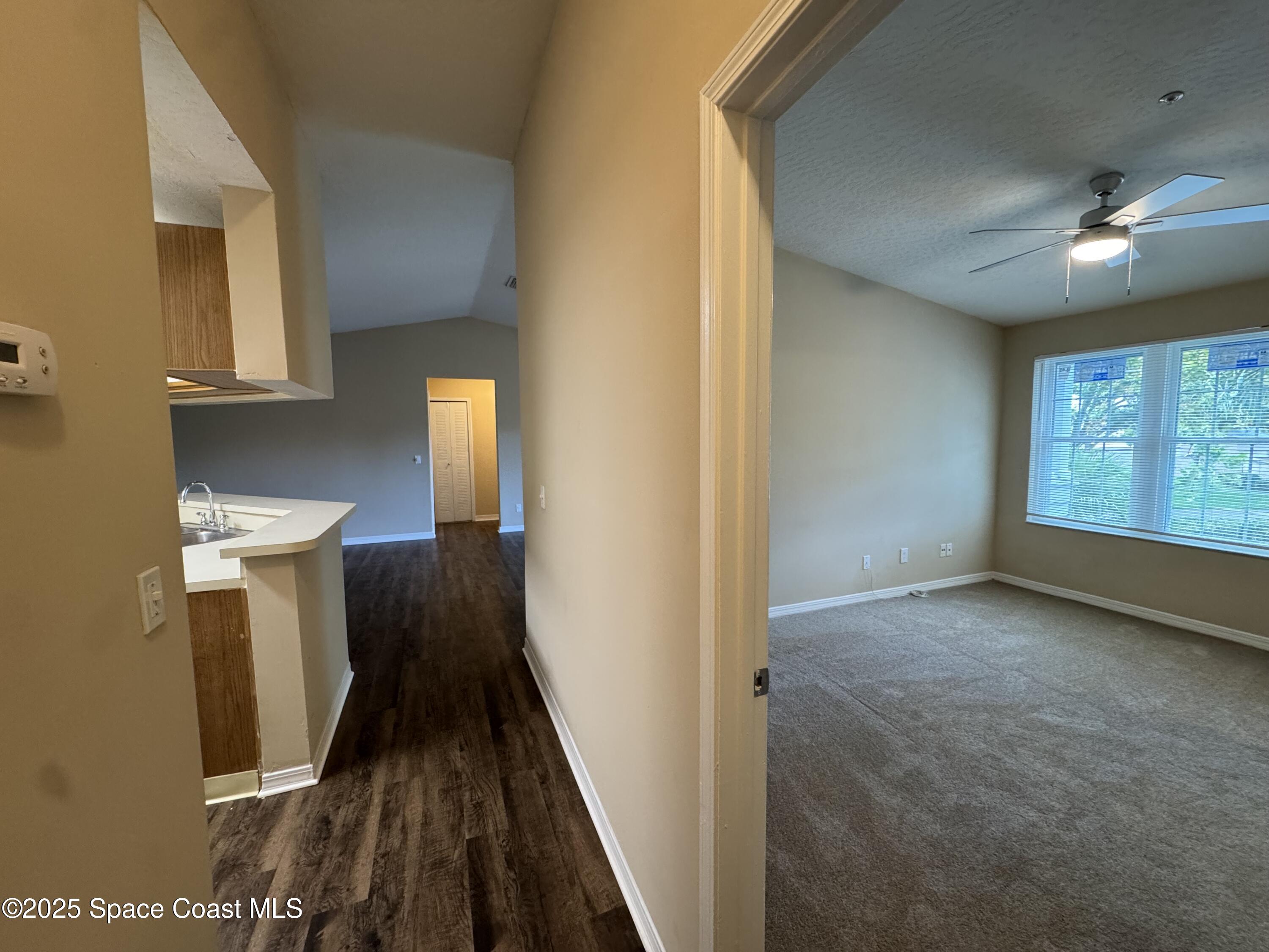 7667 North Wickham Road, Unit 1515 Melbourne, FL 32940 - Photo 3 of 36 a view of a hallway with wooden floor and staircase