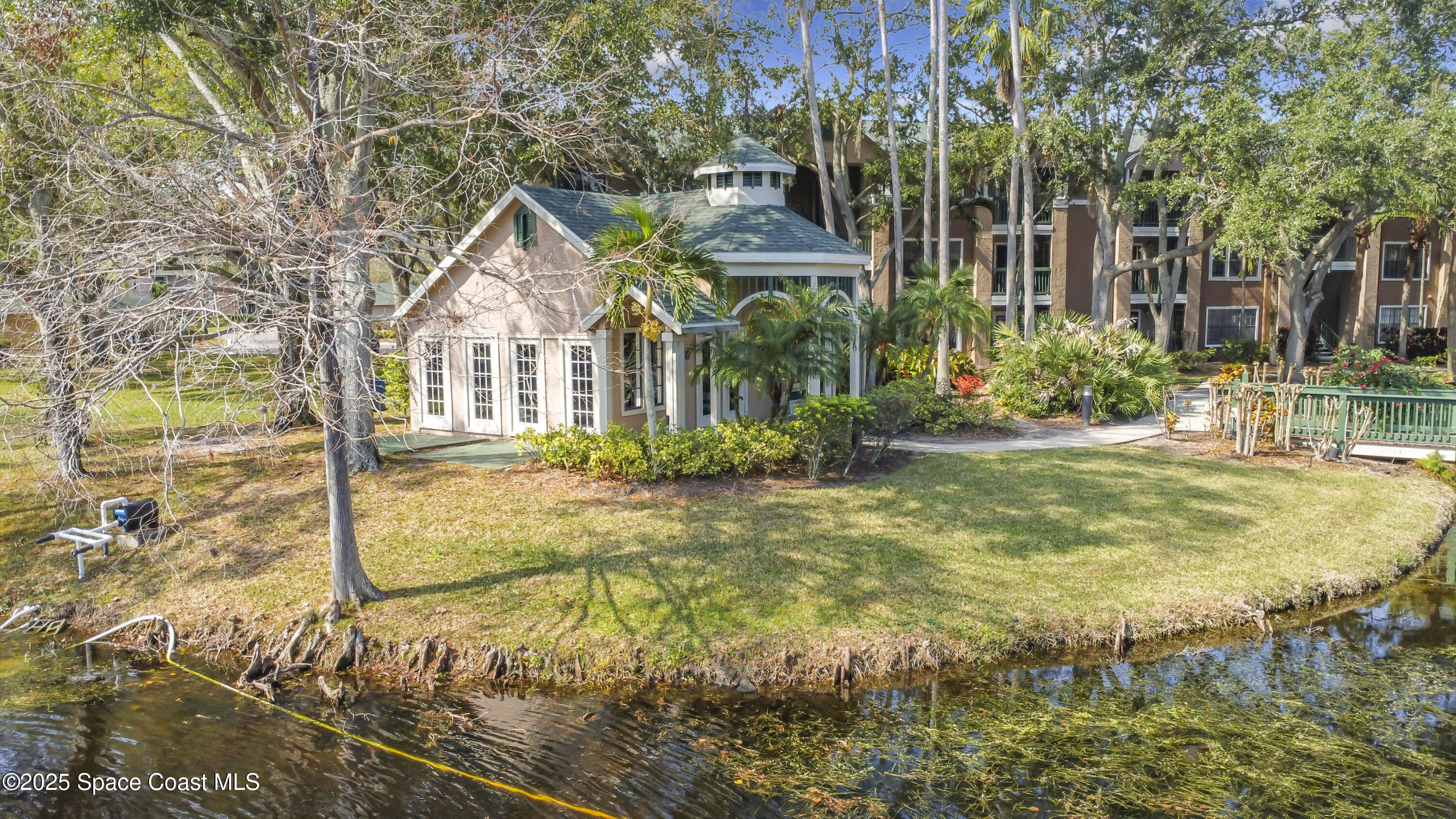 7667 North Wickham Road, Unit 1515 Melbourne, FL 32940 - Photo 32 of 36 a view of a house with large trees and plants
