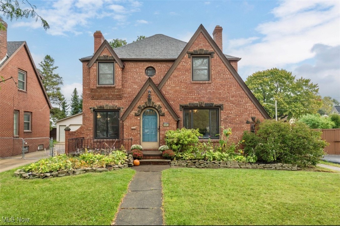 3693 Warren Road Cleveland, OH 44111 - Photo 1 of 37 English style home with a chimney, brick siding, and a garage