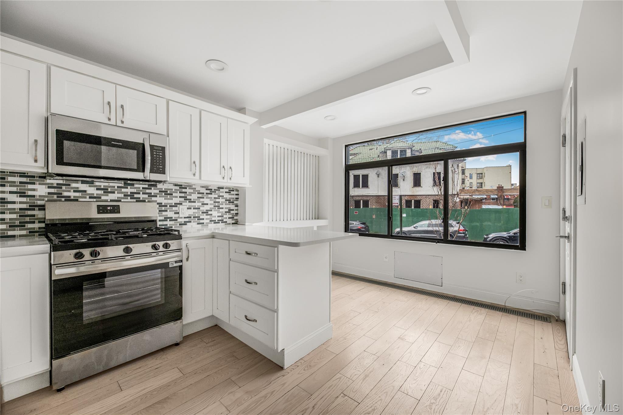 3067 Williamsbridge Road Bronx, NY 10467 - Photo 17 of 29 a kitchen with stainless steel appliances white cabinets a stove and a refrigerator