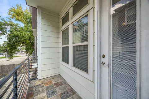 a view of empty room with kitchen view and wooden floor