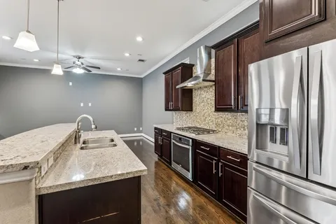 a kitchen with stainless steel appliances granite countertop a sink a stove and a wooden floors