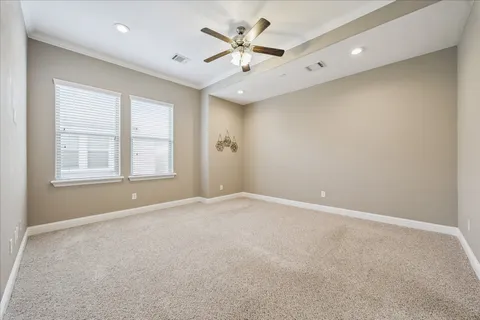 an empty room with ceiling fan and window