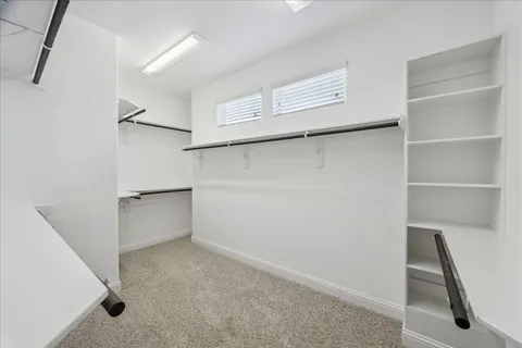 an empty room with a window and a ceiling fan