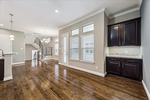 a view of an empty room with a kitchen and wooden floor
