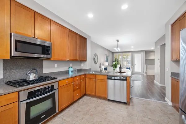a kitchen with stainless steel appliances granite countertop a stove a sink and a microwave