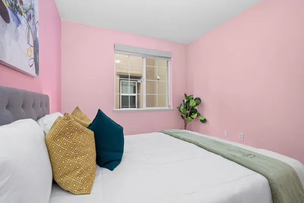 a bedroom with a bed and a potted plant