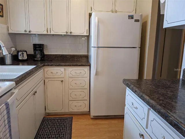 a kitchen with a refrigerator sink and cabinets