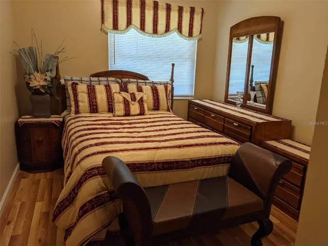 a bedroom with a bed a mirror and dresser