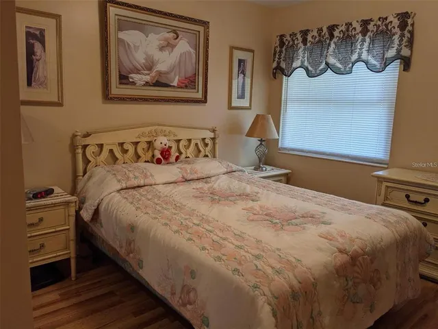 a bedroom with a bed and a painting on the wall