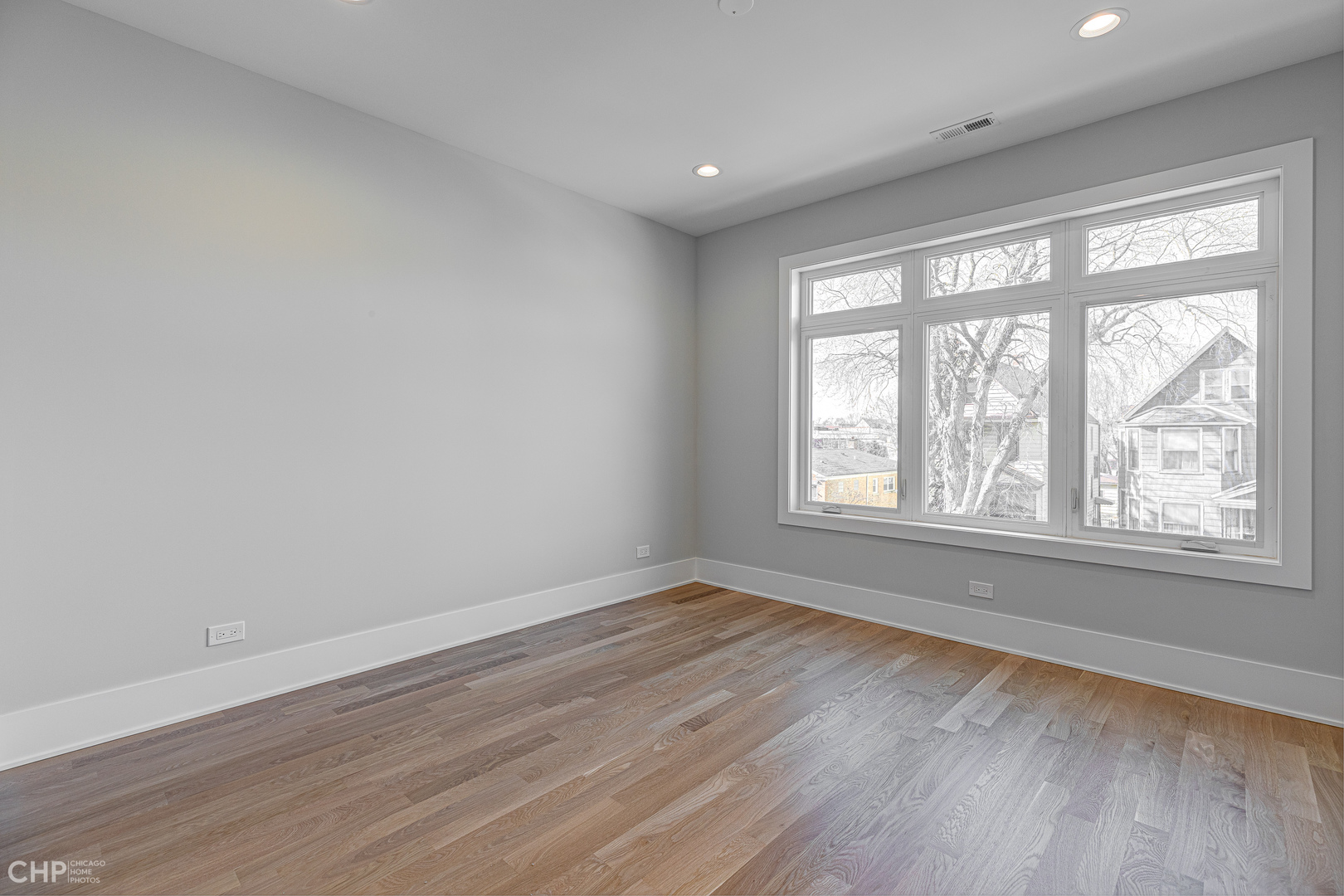 3711 North Spaulding Avenue Chicago, IL 60618 - Photo 26 of 35 a view of an empty room with wooden floor and a window